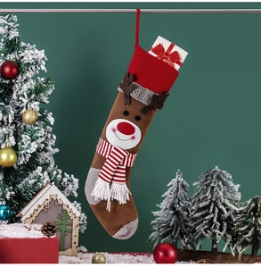 Detail of a brown knitted reindeer Christmas stocking with red scarf and 3D antlers