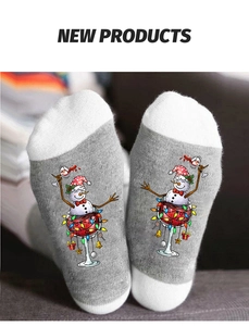 Detailed view of grey Christmas socks featuring a snowman in a wine glass with lights