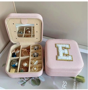 Detail view of pink leather jewelry box with mirror, earring studs, and ring slots