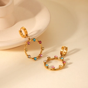 Détail de boucles d'oreilles plaquées or 18 carats avec cristaux colorés sur plateau