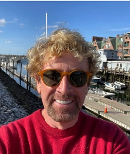 Retro TR90 polarized sunglasses with orange semi-rimless frames worn by person in red sweater