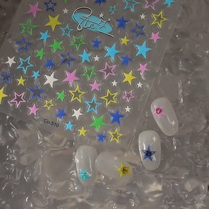Macro shot of colorful star nail stickers applied on clear tips over water ripple background