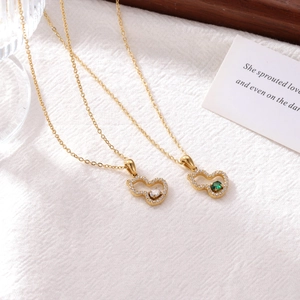 Collier gourde doré élégant avec pierre émeraude sur fond de tissu en lin blanc cassé