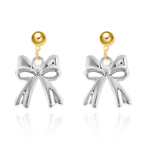 Detailed close-up of silver bow pendant earrings with gold spherical studs and reflection