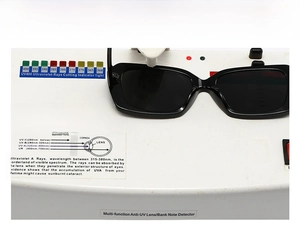 Test UV400 dettagliato che mostra occhiali da sole squadrati neri sul tester digitale