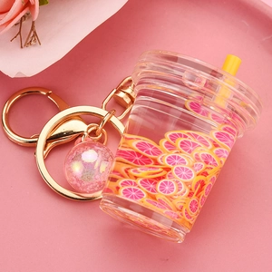 Macro detail of acrylic beverage keychain with pink liquid and citrus slices charm
