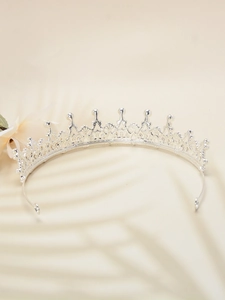 Detailed view of an ornate silver bridal tiara with intricate filigree on a soft background