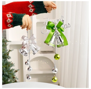 Detail of silver and green Christmas bell ornaments with silk bows and pearl accents