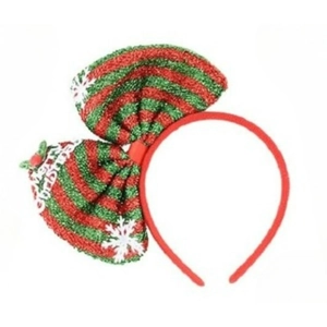 Detail of red and green striped Christmas bow headband with white snowflake patterns