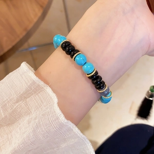 Detailed shot of multi-color beaded bracelet with blue turquoise and black onyx on wrist