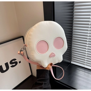 Detailed shot of ghost skull crossbody bag with pink accents and metal zipper