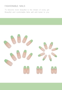 Close-up of long coffin-shaped French press-on nails in green and pink with rhinestones