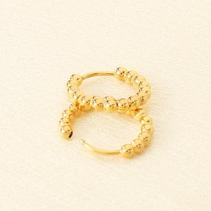Detailed close-up of classic 18K gold plated stainless steel bead hoop earrings on fabric
