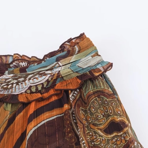 Detail of bohemian print fabric with gold lurex stripes and layered ruffle design