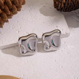 Detailed close-up of silver-tone liquid lava style stud earrings with a mirrored finish