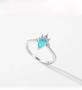 Macro detail of crown shaped S925 silver ring with pear cut blue tourmaline gemstone