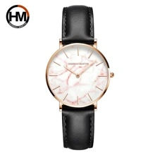 Close-up of minimalist lady watch with marble texture dial and black leather strap
