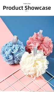 Detailed close-up of soft mesh shower puffs in blue, pink, and white with satin lanyards