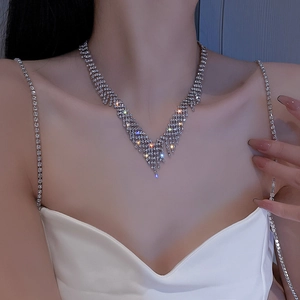 Gros plan du collier ras du cou à strass étincelants montrant des franges en V sur le cou