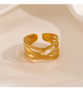Macro detail of gold-plated multi-layer crossover ring on elegant white satin fabric