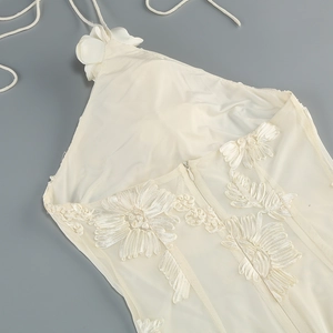 Detail of floral lace embroidery and mesh fabric on a halter neck dress with hidden zipper
