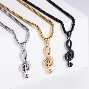 Detailed view of music note pendants in silver, gold, and black finishes on white blocks