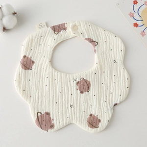 Detail of petal-shaped cotton baby bib featuring a cute brown bear pattern and snap button