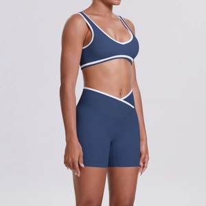 Detail view of navy yoga bra and high-waist shorts with white piping and V-cut waistband