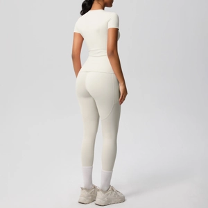 Vista posteriore del set yoga crema con top a maniche corte e leggings a vita alta