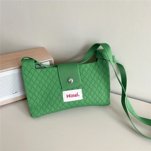 Detail of green knitted crossbody bag with diamond texture and magnetic buckle