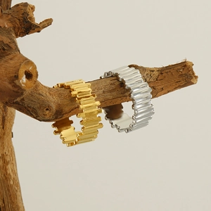 Detail of gold and silver adjustable stainless steel rings on a natural wood branch