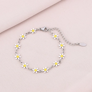 Close-up of silver stainless steel daisy bracelet with white enamel petals on pink fabric