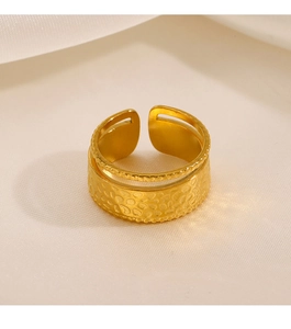 Macro view of gold hammered texture ring with beaded edges on white satin background