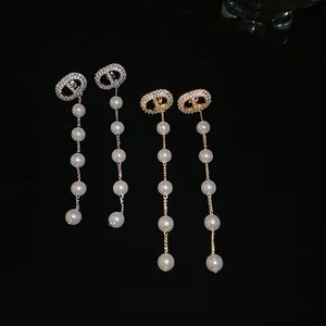 Elegant five-pearl drop earrings with rhinestone CD studs in gold and silver finishes