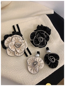 Detailed view of camellia hair accessories with satin petals and pearl accents