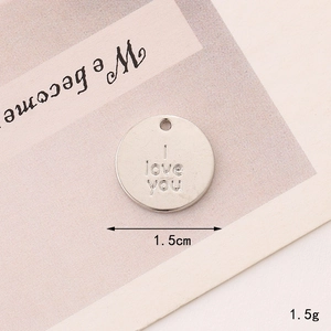 Macro shot of silver I Love You pendant showing 1.5cm diameter and 1.5g weight detail