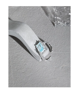 Detailed macro of S925 silver ring featuring a light blue gemstone and foil texture