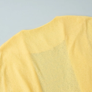 Detailed macro view of yellow translucent knit fabric and clean neckline stitching