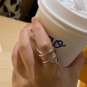 Close-up of a silver multi-layer crossover ring featuring a modern minimalist line design