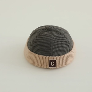 Detailed texture of baby knit miki hat with brown square C patch and ribbed fabric
