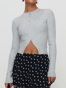Détail du cardigan en maille grise montrant la fermeture à boutons et la texture