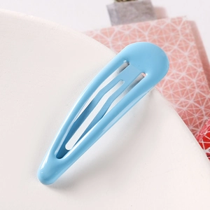 Detailed macro view of a light blue matte snap hair clip with a sleek teardrop design