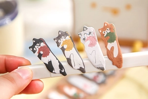 Creative cat-shaped sticky index tabs for classroom notes being used on a pen