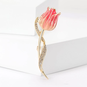 Macro shot of pink enamel tulip brooch with golden stem and sparkling rhinestones