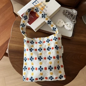 Detailed embroidery on floral canvas tote bag showing stitching and fabric texture