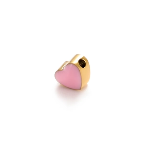 Macro shot of pink enamel heart pendant with golden metal base for jewelry making