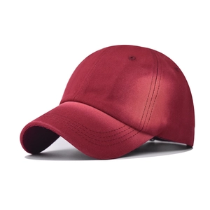 Detail view of wine red washed cotton baseball cap with embroidered eyelets and curved brim