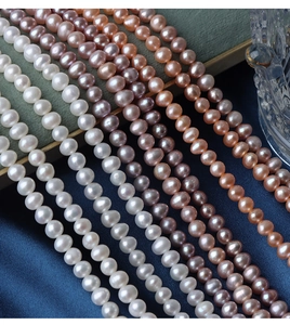 Close-up of high luster white, pink and purple freshwater pearls on luxury silk fabric