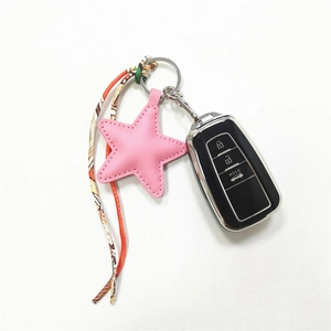 Pink leather star keychain with printed silk scarf strap and metal ring on white background