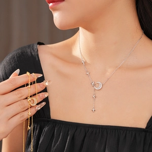 Detail of silver and gold moon and star pendant necklaces with cubic zirconia inlay